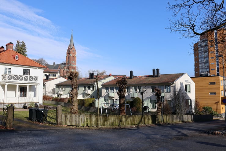 Brf Åbybergsparkens radhus med Krokslätts kyrka och andra högre hus u bakgrunden